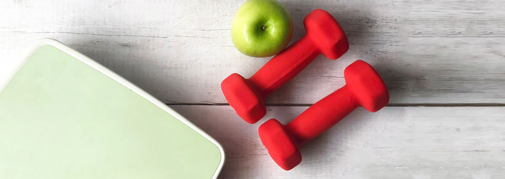 weighing scale dumbbells and apple