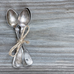 Teaspoons placed on top of a wooden table.