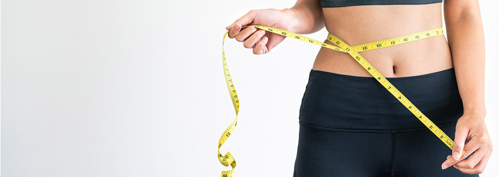 Woman measuring her waistline