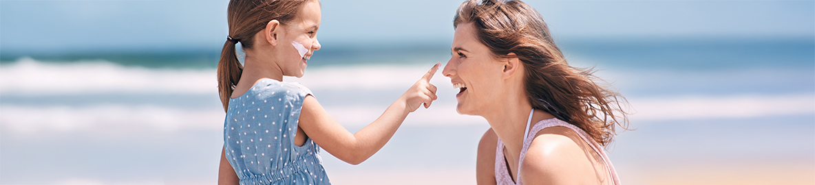 mom putting sunscreen daughters face