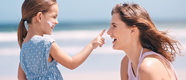 mom putting sunscreen daughters face