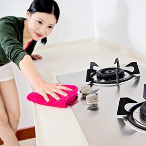 woman cleaning kitchen surface
