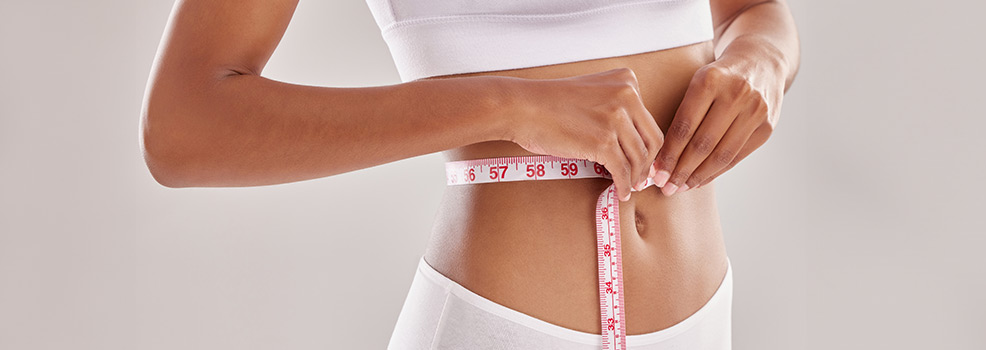 woman measuring her waistline
