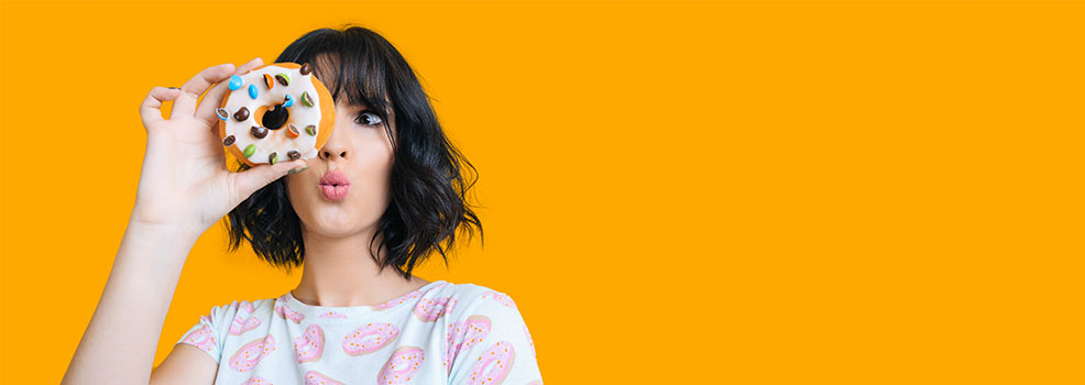 Mujer morena observando una dona