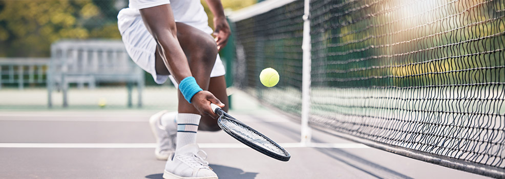 active adult playing tennis outdoors